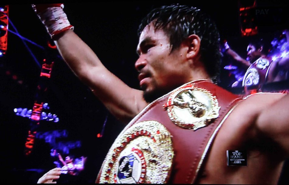 Pacquiao raises his arm in victory against Rios by unanimous decision.